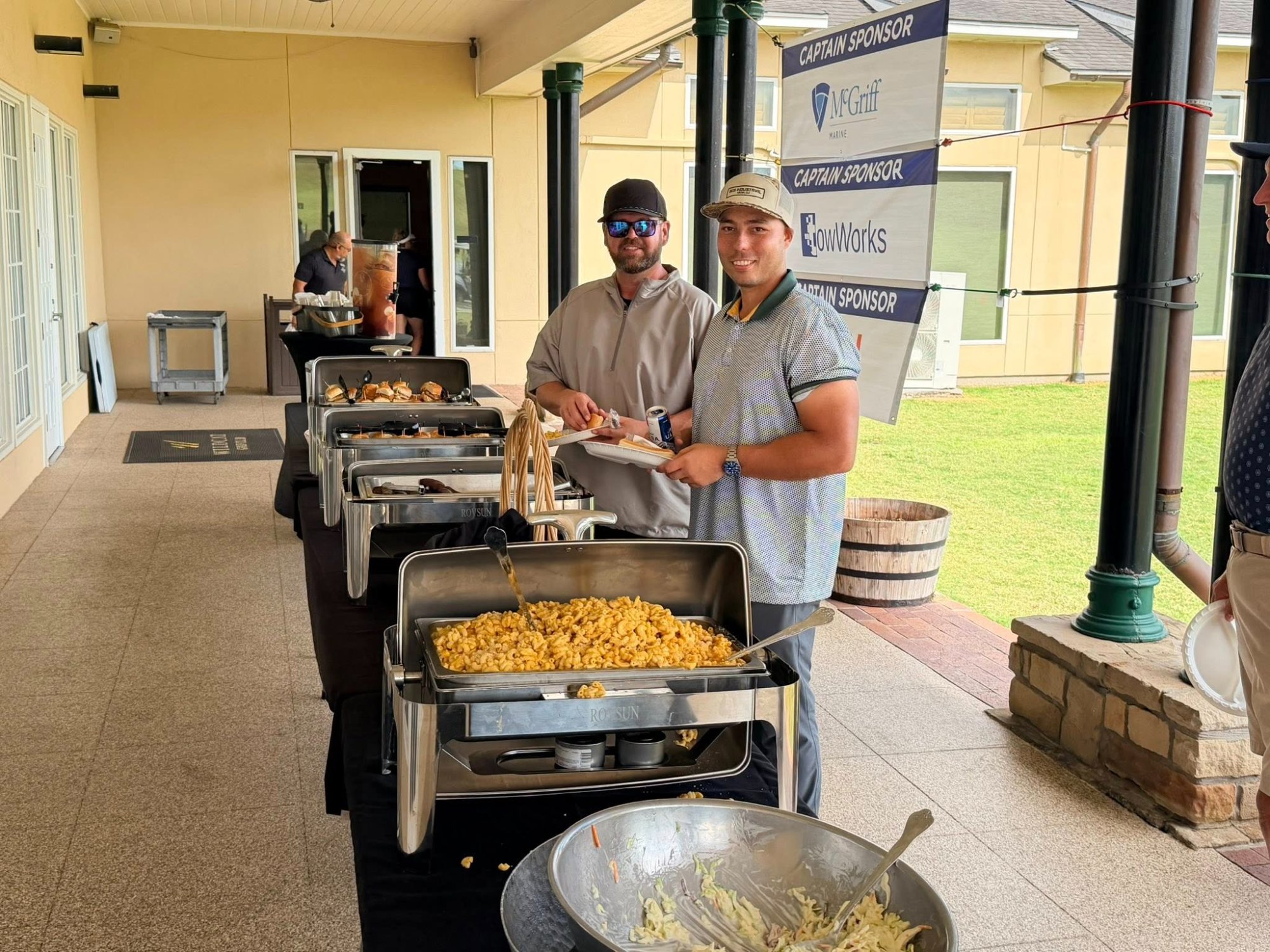 Propeller Club of Houston golf tournament — GCS team at the catering spread with sponsor banners visible