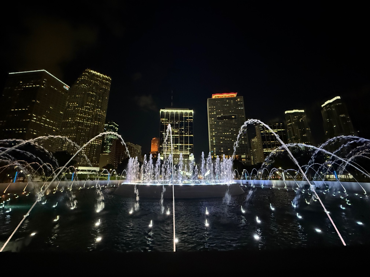 Miami downtown Bayside fountain lit up at night with city skyline behind — Biscayne Bay waterfront